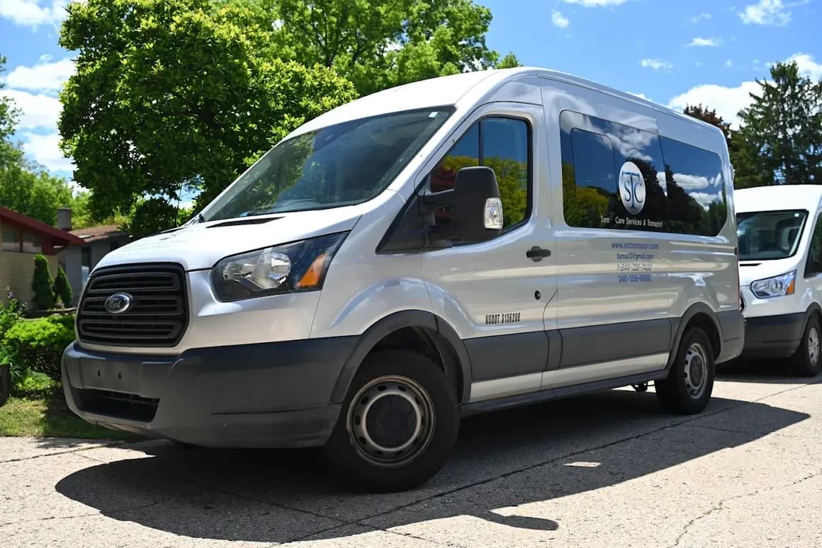 A silver Senior Care Services & Transport van parked on a sunny residential street.
